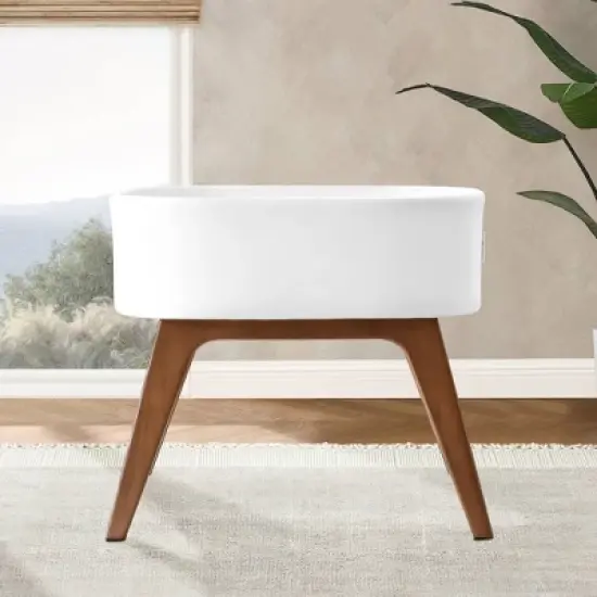 Delta Children Aero Bassinet Modern Portable Baby Crib with Solid Wood Legs, Mattress Pad and Fitted Sheet - White image {1}